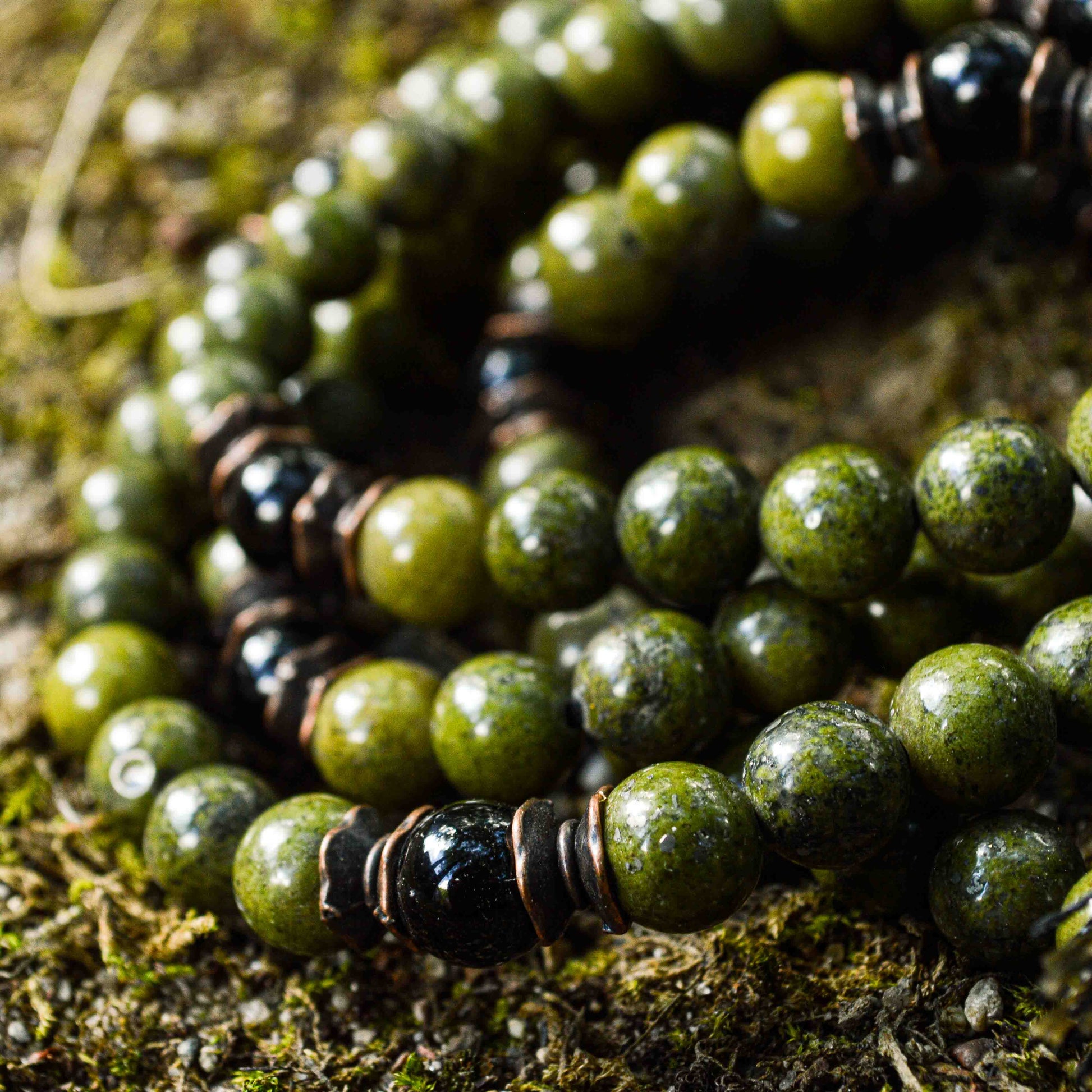 Close-up view of Green African Jade and Black Tourmaline mala beads showing natural stone variations and textures