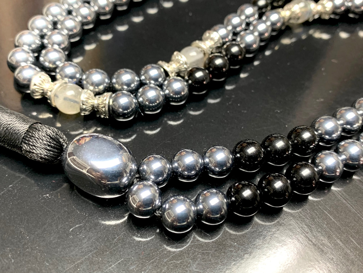 Detail shot of black tourmaline, terahertz and labradorite beads for root and third eye chakras

