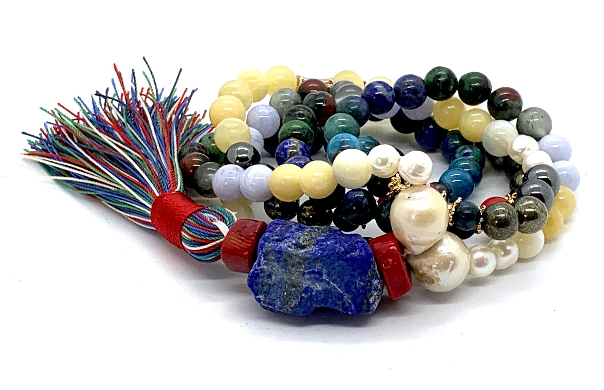 Close-up view of Cosmic Harmony Mala beads showing ruby zoisite, coral, pearl and multi-colored gemstones