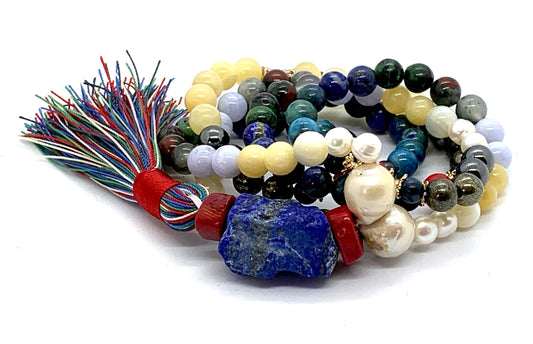 Close-up view of Cosmic Harmony Mala beads showing ruby zoisite, coral, pearl and multi-colored gemstones